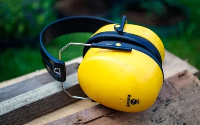 Żółte nauszniki ochronne leżące na drewnianej powierzchni